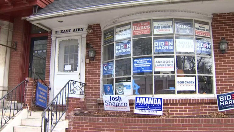 Multiple campaign signs and posters, including some supporting President Joe Biden and Vice President Kamala Harris, adorn the front window of the Montgomery County Democratic Committee’s Norristown office. (NBC10)