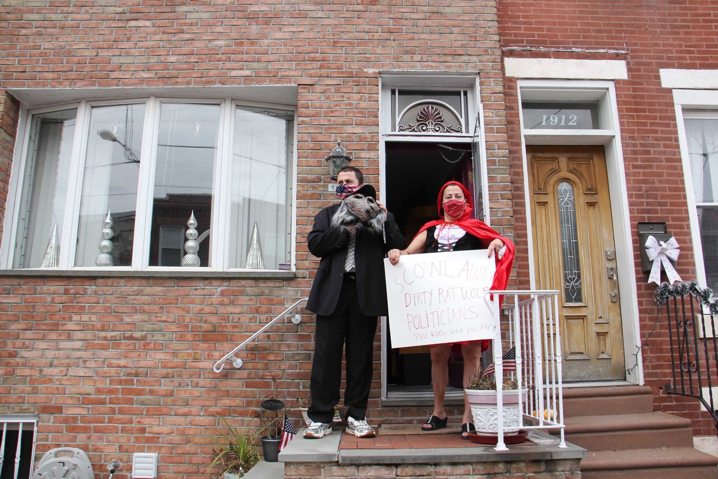 Maureen Fratantoni, dressed as Little Red Riding Hood, and her son, son James Fratantoni, the big bad wolf-rat, show support for those protesting the cancellation of the Mummers Parade from their front stoop on 11th Street.