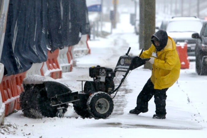 A man works to turn his snow-clearing machine