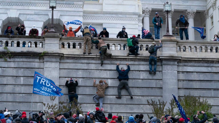 Supporters of President Donald Trump climb the west wall of the the U.S. Capitol on Wednesday, Jan. 6, 2021, in Washington.