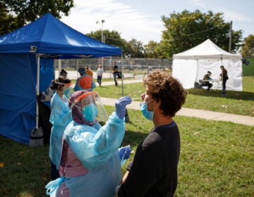 A volunteer administers a COVID-19 test in Mifflin Square Park