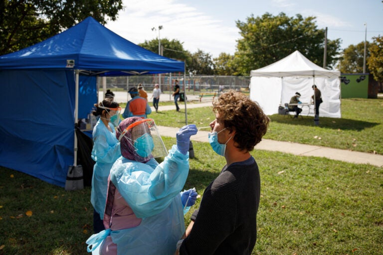 A volunteer administers a COVID-19 test in Mifflin Square Park