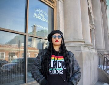 Danielle Jackson, the 'Hoodbrarian,' stands outside the old Camden Public Library building on Federal Street, which has been abandoned since 2011. (Emma Lee/WHYY)