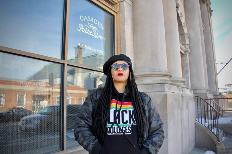 Danielle Jackson, the 'Hoodbrarian,' stands outside the old Camden Public Library building on Federal Street, which has been abandoned since 2011. (Emma Lee/WHYY)