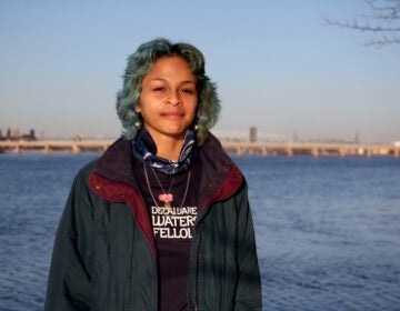 Adrianna Amador-Chacon, 20, of Camden, stands near the Delaware River at Cramer Hill Nature Preserve. (Emma Lee/WHYY)