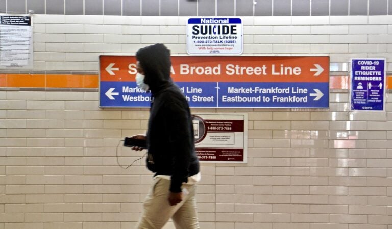 A SEPTA passnger walks toward the subway entrance. (Emma Lee/WHYY)