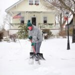 A Moorestoown, N.J., resident clears the snow in front of her house on Monday, Feb. 1, 2021. (Emma Lee/WHYY)