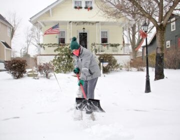 A Moorestoown, N.J., resident clears the snow in front of her house