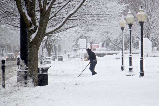 A shoveler clears the walkway to Our Lady of Good Counsel Church