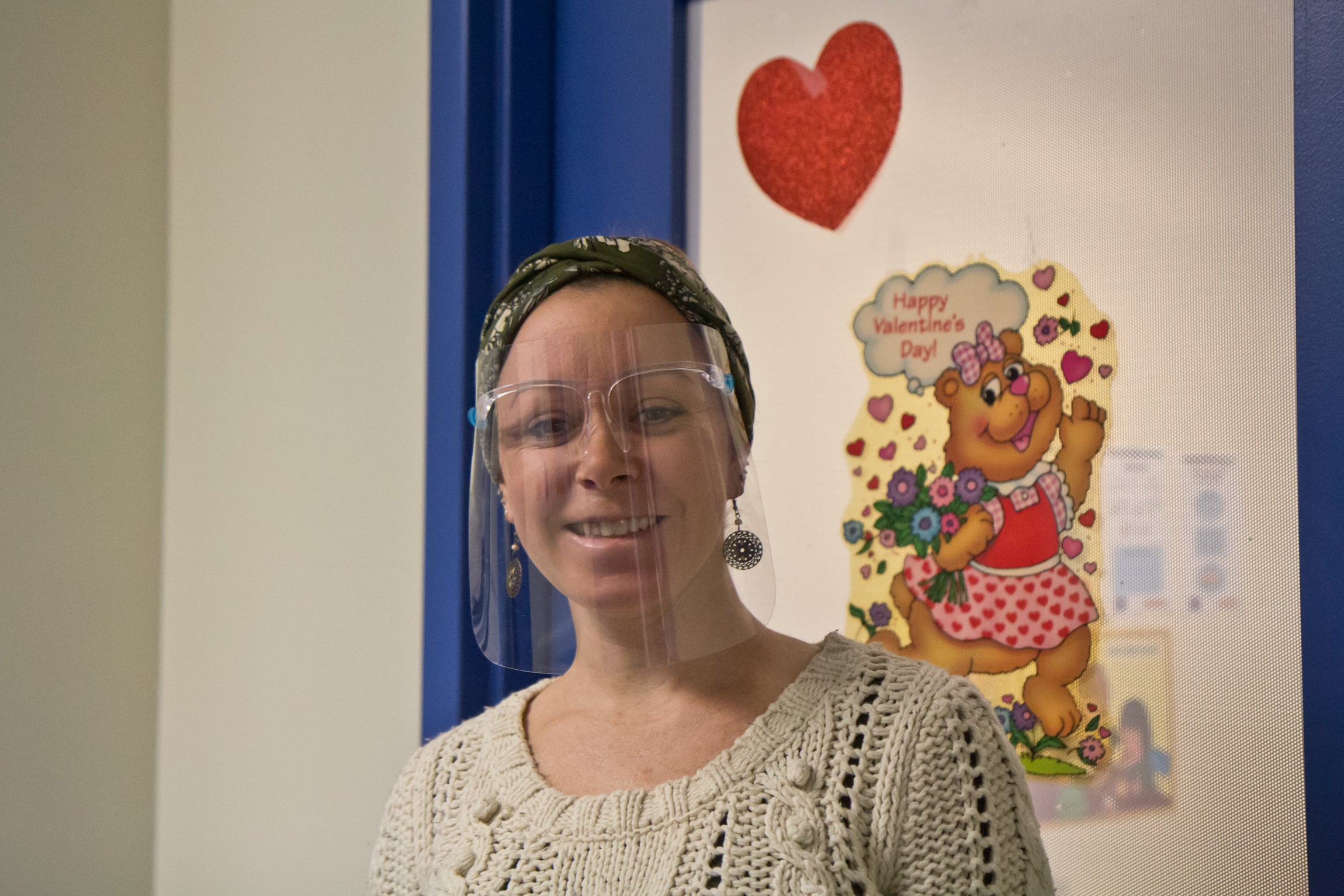 Erin Walsh smiles while wearing a face mask