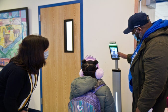 Sana Stewart, 6, receives a temperature check