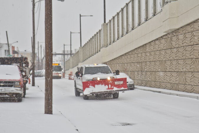 A plow truck rolls around Fishtown during a winter storm