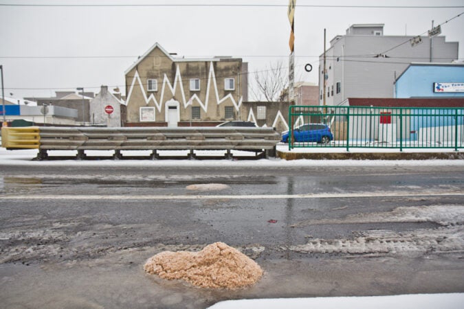 Rock salt used to de-ice roads piles on Girard Avenue during a snow storm