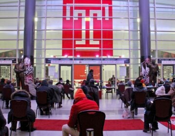 Philadelphians wait in the lobby of the Liacouras Center at Temple University to receive the Moderna COVID-19 vaccine.