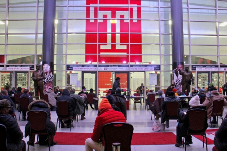 Philadelphians wait in the lobby of the Liacouras Center at Temple University to receive the Moderna COVID-19 vaccine.