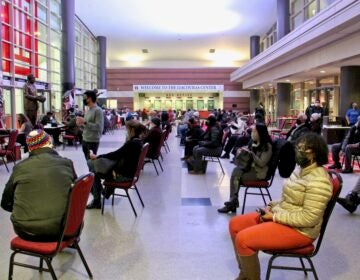 Philadelphians wait in the lobby of the Liacouras Center at Temple University to recieve the Moderna COVID-19 vaccine. The 24-hour vaccination event was organized by the Black Doctors COVID-19 Consortium. (Emma Lee/WHYY)