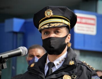 Philadelphia Police Commissioner Danielle Outlaw speaks into a microphone, wearing a mask and standing behind a podium.