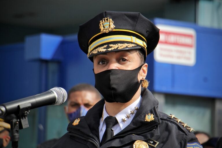 Philadelphia Police Commissioner Danielle Outlaw speaks into a microphone, wearing a mask and standing behind a podium.