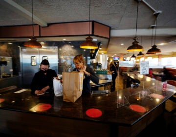 Managers Yllka Murati, left, and Cynthia Branche organize takeout orders at the Penrose Diner, Tuesday, Nov. 17, 2020, in South Philadelphia. (AP Photo/Matt Slocum)