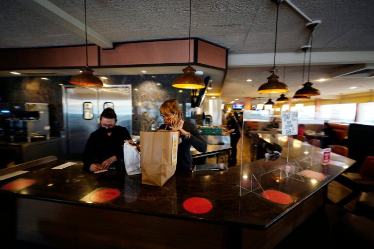 Managers Yllka Murati, left, and Cynthia Branche organize takeout orders at the Penrose Diner, Tuesday, Nov. 17, 2020, in South Philadelphia. (AP Photo/Matt Slocum)