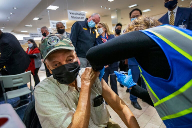 New Jersey Gov. Phil Murphy (background) listens to New Jersey Department of Health Commissioner Judy Persichilli as World War II veteran Clarence Williams get vaccinated for COVID-19. (Alejandro A. Alvarez/The Philadelphia Inquirer via AP, Pool)