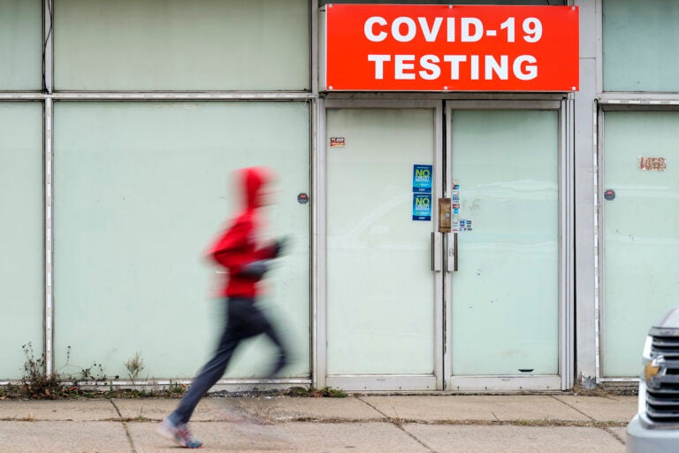 A person jogs by a COVID-19 testing site in Philadelphia, Monday, Jan. 25, 2021. (AP Photo/Matt Rourke)