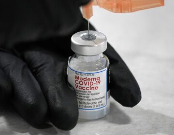 A syringe is loaded with a dose of the Moderna COVID-19 vaccine
