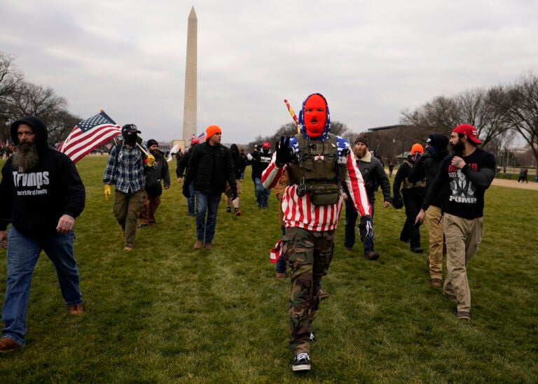 FILE - In this Jan. 6, 2021, file photo, people march with those who say they are members of the Proud Boys as they attend a rally in Washington in support of President Donald Trump. In its annual report set to be released Monday, Feb. 1, 2021, the Southern Poverty Law Center said it identified 838 active hate groups operating across the U.S. in 2020. The SPLC’s report comes out nearly a month after a mostly white mob of Trump supporters and members of far-right groups violently breached the U.S. Capitol building. (AP Photo/Carolyn Kaster, File)