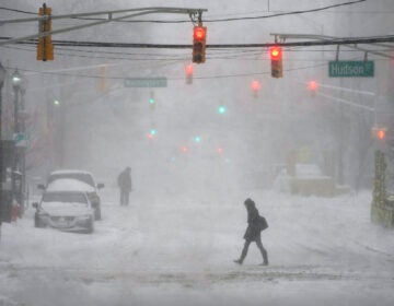 A few pedestrians are seen walking in the heavy snow and wind in Hoboken, N.J., Monday, Feb. 1, 2021. (AP Photo/Seth Wenig)