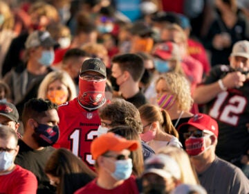 People wait in line for an exhibit at the NFL Experience Thursday, Feb. 4, 2021, in Tampa, Fla. The city is hosting Sunday’s Super Bowl football game between the Tampa Bay Buccaneers and the Kansas City Chiefs. (AP Photo/Charlie Riedel)