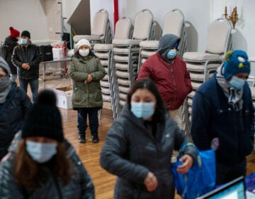 People wait to fill out forms at the community center Mixteca to receive food and get information about the COVID-19 vaccination during the coronavirus pandemic, Saturday, Feb. 13, 2021, in Brooklyn. (AP Photo/Eduardo Munoz Alvarez)