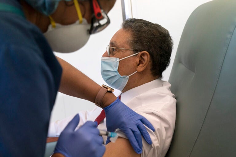 In this Wednesday, Feb. 10, 2021, photo Wallace Charles Smith, 72, who is a pastor at Shiloh Baptist Church, receives his first COVID-19 vaccination by nurse Michelle Martin, at United Medical Center in southeast Washington. (AP Photo/Jacquelyn Martin)