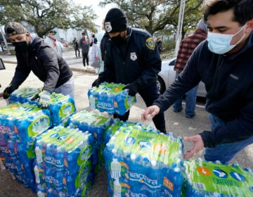 Donated water is distributed to residents, Thursday, Feb. 18, 2021, in Houston. Houston and several surrounding cities are under a boil water notice as many residents are still without running water in their homes. (AP Photo/David J. Phillip)