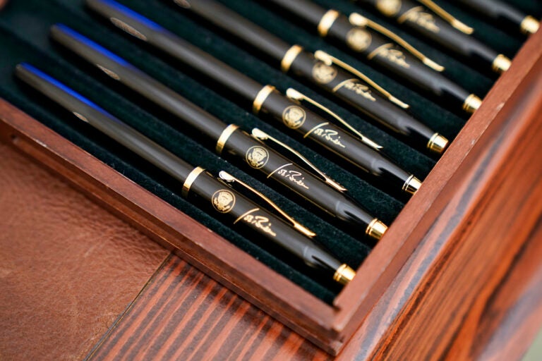 Pens featuring President Joe Biden’s signature and presidential seal, are displayed  in the State Dinning Room of the White House, Thursday, Jan. 21, 2021, in Washington. (AP Photo/Alex Brandon)