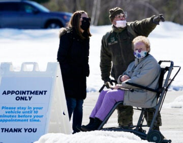 Sgt. Richard Grant of the Air National Guard helps point a patient in the right direction at a COVID-19 vaccination site at the Augusta Civic Center, Friday, Feb. 26, 2021, in Augusta, Maine. (AP Photo/Robert F. Bukaty)