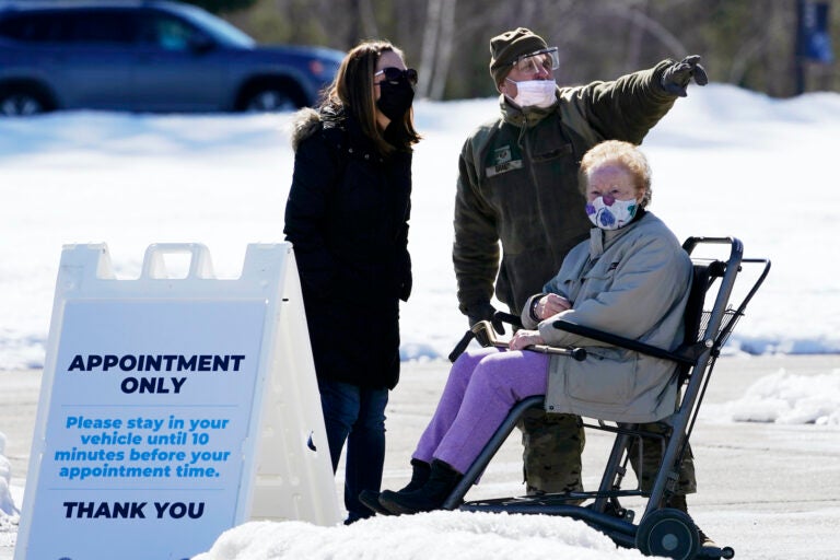 Sgt. Richard Grant of the Air National Guard helps point a patient in the right direction at a COVID-19 vaccination site at the Augusta Civic Center, Friday, Feb. 26, 2021, in Augusta, Maine. (AP Photo/Robert F. Bukaty)