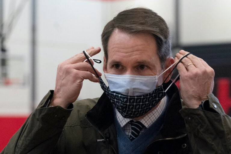 Congressman Jim Himes, D-Conn., adjusts his two masks