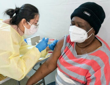 Registered Nurse Shyun Lin, left, gives Alda Maxis, 70, the first dose of the COVID-19 vaccine at a pop-up vaccination site