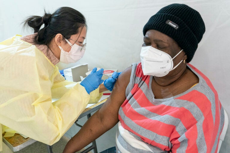 Registered Nurse Shyun Lin, left, gives Alda Maxis, 70, the first dose of the COVID-19 vaccine at a pop-up vaccination site