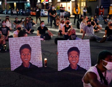 In this Aug. 24, 2020, file photo, two people hold posters showing images depicting Elijah McClain during a candlelight vigil for McClain outside the Laugh Factory in Los Angeles. (AP Photo/Jae C. Hong, File)