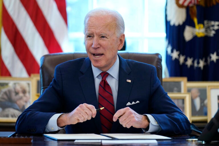 President Joe Biden signs a series of executive orders in the Oval Office