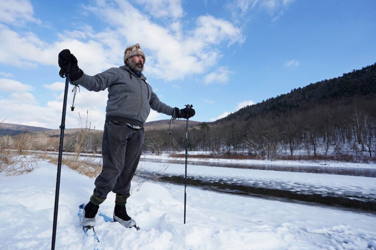 Steve Schwartz uses skis to get around in the snow on his property right along the Delaware River in Equinunk, Pennsylvania. (Matt Smith/WHYY)