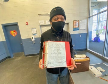 Jimi Lewis, the senior skating instructor at Laura Sims Skate House, holds a flyer from 1986 that he created. (Taylor Allen/WHYY)