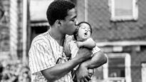 A photograph by Ken McFarlane showing a Black father kissing their baby in Movers & Makers: Made with Love