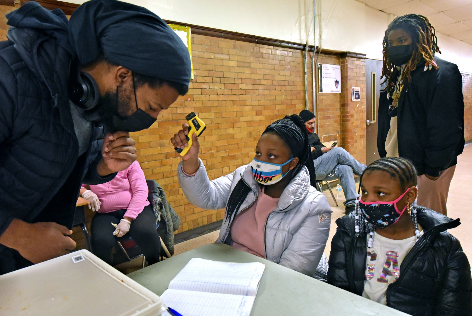 Shaniah Allen, 11, and her sister Taliah Allen, 8; take the temperatures of those who enter