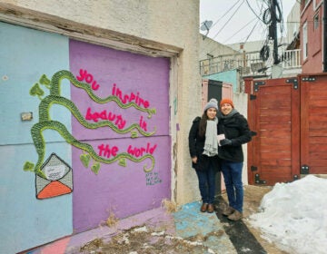 Danielle Brief and Jonah Adams stand next to a mural in South Philly