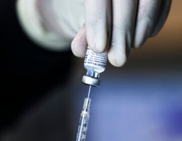 A pharmacy technician prepares doses of the Pfizer-BioNTech vaccine at a mass vaccination event on Saturday in Denver.