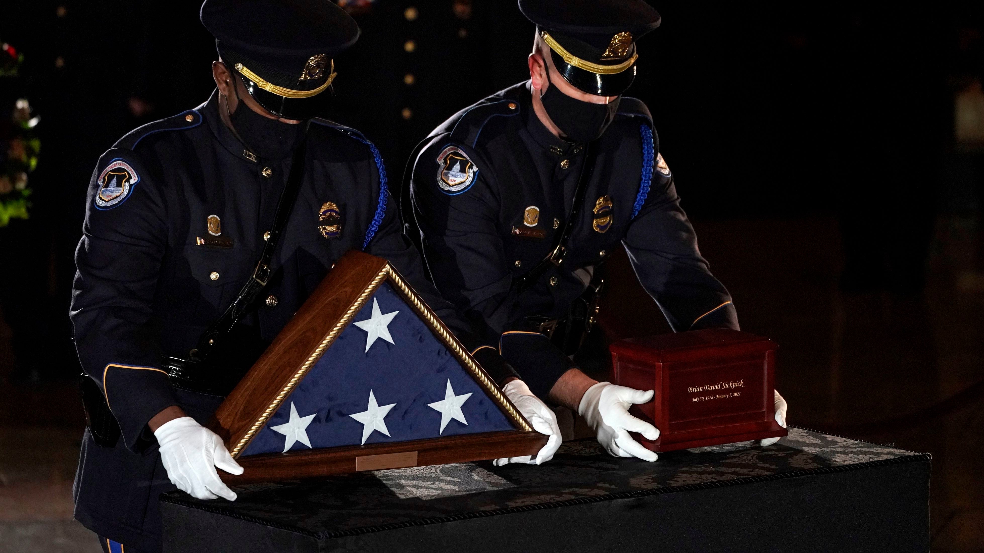 Sicknick's remains are placed next to a U.S. flag on a pedestal in the Capitol Rotunda (