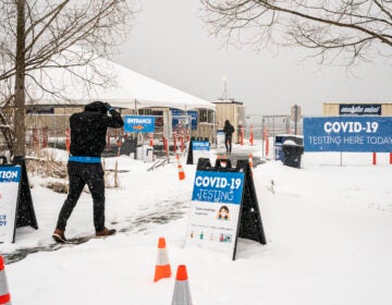 People enter a COVID-19 testing site in the snow