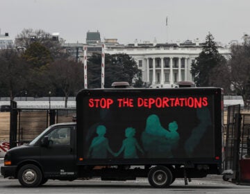 An L.E.D. truck displaying messages expressing concern over the continuing mass deportations of Black immigrants drives past the White House